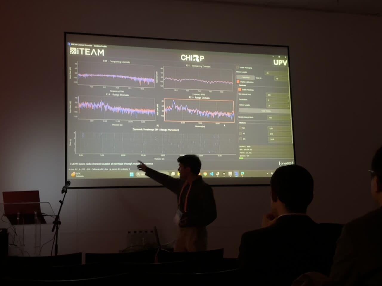 Presenting the channel sounder at European Microwave Week 2025, with frequency- and range-domain channel measurements projected on screen