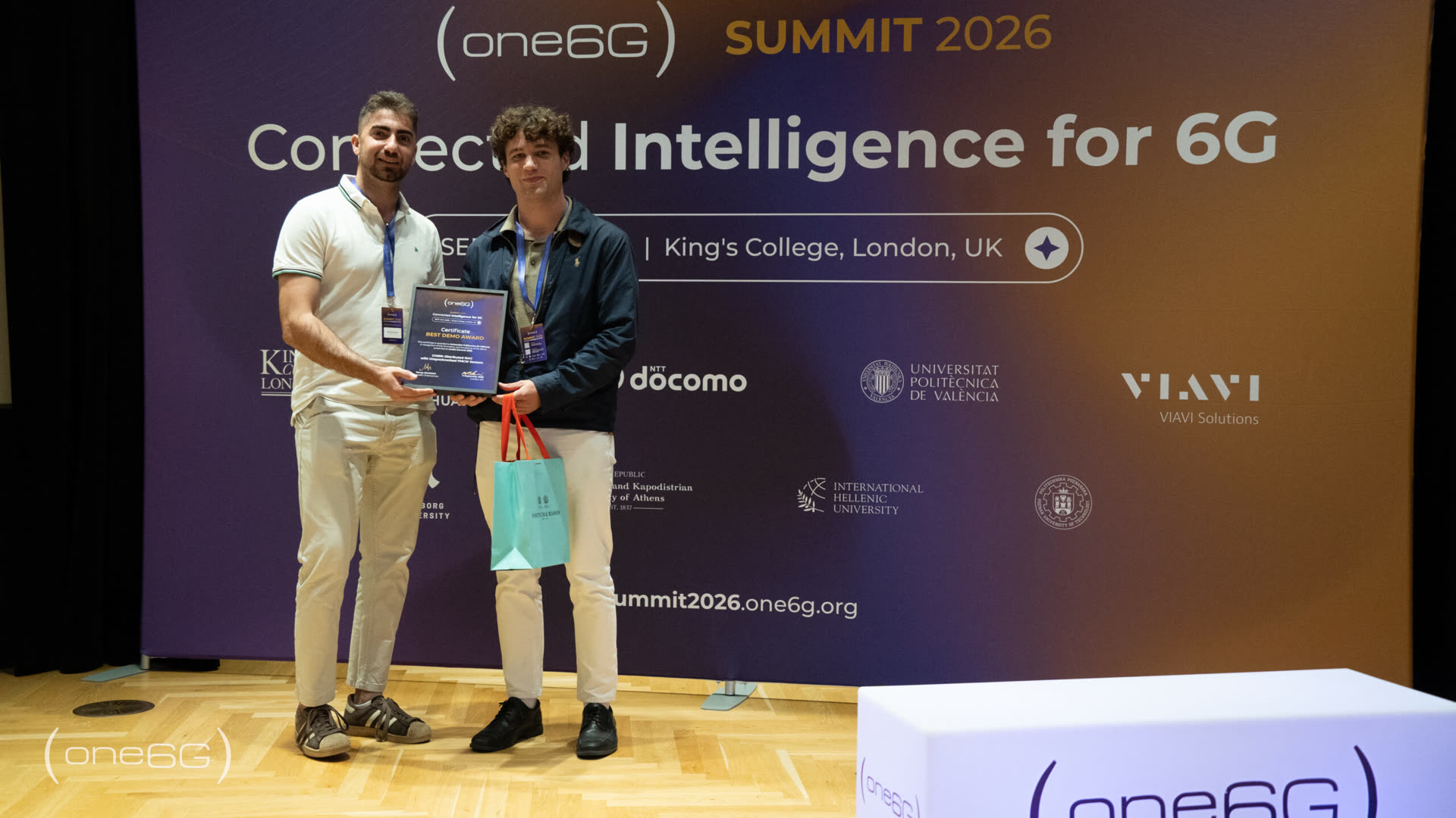 Two CHIRP team members on stage at the one6G Summit 2026 holding the Best Demo Award certificate